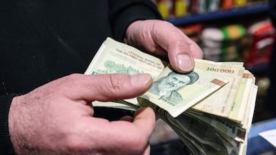 A Tehran shop owner counts Iranian banknotes. The rial falling to a record low sparked protests in the capital. AFP