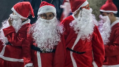Palestinian boys in Santa costumes add to the festive vibe at the Christmas tree lighting in Gaza City. EPA