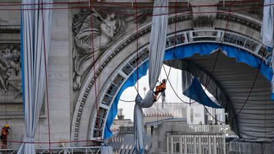 A technician is suspended in the arch way of the monument, as the final artwork of Christo and Jean Claude is taken apart. AP Photo