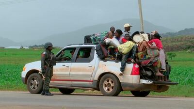 Nigerian security personnel check a pickup truck loaded with people and their belongings as they flee the town of Jos on June 25, 2018 after weekend clashes in central Nigeria between mostly Muslim herders and Christian farmers. Nigeria government via AP