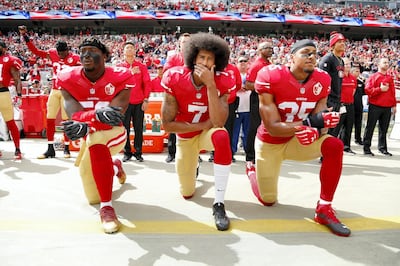 Colin Kaepernick, centre, and other players of San Francisco 49ers kneel during the US national anthem in 2016. EPA