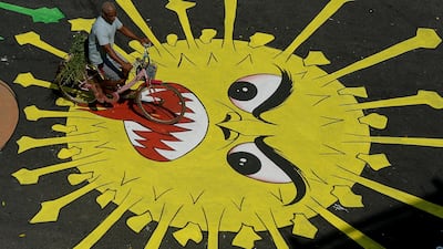 A motorist rides past graffiti painted on a road to raise awareness about coronavirus. AFP