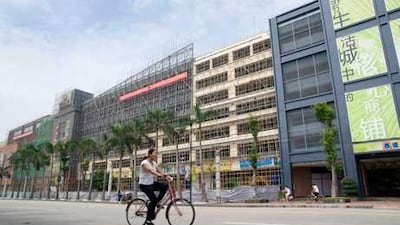 A cyclist passes the long bamboo-scaffolded eastern facade of the South China Mall. Philip Gostelow for The National