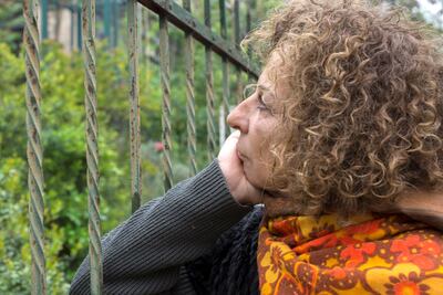 Huda Imam looks through the railing of her father's home. “I see it like a prison, like I’m in prison and can’t actually see the house,” she says. “Although it is my father’s house, which he built it stone by stone." William Parry for The National