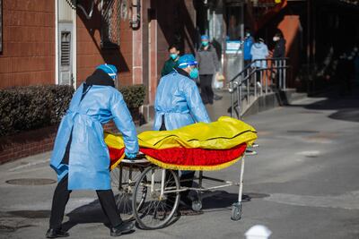 Volunteers push a stretcher carrying what appears to be a body bag in front of a 'fever clinic' in Beijing. EPA