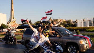 Supporters of Syrian President Bashar Al Assad hold up national flags at an election gathering at Umayyad Square, in the capital Damascus, on Sunday, May 23. AP Photo
