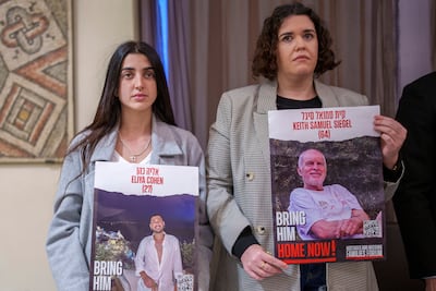 Tal Wax, right, and Ziv Abod hold posters of their relatives hostages held in Gaza since the October 7 attacks by Hamas. AP Photo