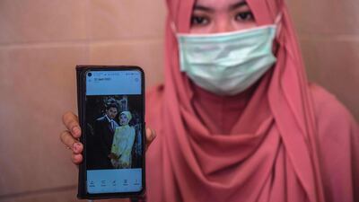 Berda Asmara shows a wedding photo with her sailor husband Mes Guntur Ari Prasetyo at their home in Surabaya. AFP
