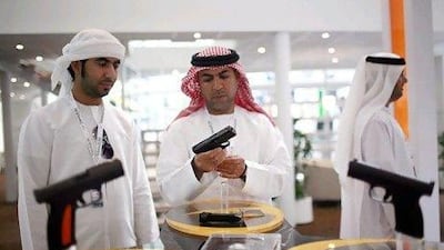 Abu Dhabi - February 25, 2009: Men look at pistols at the Caracal stand during the International Defence Exhibition and Conference 2009 (IDEX) at the Abu Dhabi National Exhibition Centre. Gunmaker Caracal is located in Tawazun Industrial Park. ( Philip Cheung / The National ) *** Local Caption *** PC0150-IDEX.jpgPC0150-IDEX.jpg