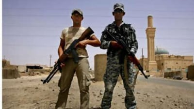 Oday Abdul Qader, left, a Sunni, and his friend Abdul Qader Salah, a Shiite, guard their checkpoint in Samarra.