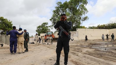 Somali policemen stand at the scene after a suicide car bomber drove into a checkpoint outside the port in Mogadishu. Reuters
