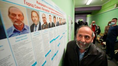 Boris Vishnevsky of the Yabloko party who was running for both the State Duma and the regional legislature, looks at a candidates list in St Petersburg, Russia. Mr Vishnevsky discovered that there were two other men running in both races under the same name as him. AP