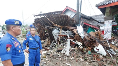 Indonesian police officers look at the devastation. EPA