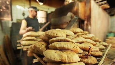 A baker removes subsidised bread from an oven in Egypt, one of the world's largest wheat importers.