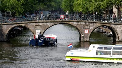 Tourists boats pass on a canal in Amsterdam, Netherlands, May 16, 2018. Picture taken May 16, 2018. Reuters