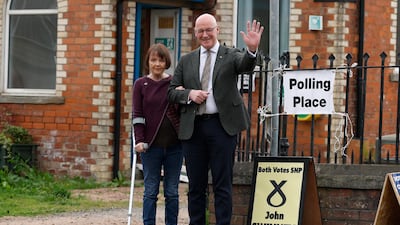 Scotland's First Minister and Scottish National Party leader John Swinney and wife Elizabeth pose after casting their votes in Burrelton, Scotland. Getty Images