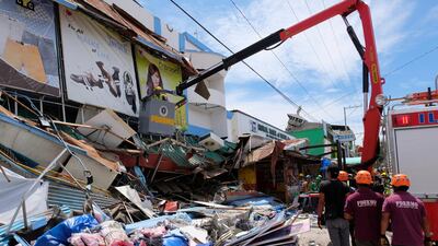 Rescue workers inspect a damaged building in Digos, Davao del Sur, southern Philippines on Thursday Oct. 31, 2019. The third strong earthquake this month jolted the southern Philippines on Thursday morning, further damaging structures already weakened by the earlier shaking. (AP Photo/Romer S. Sarmiento)