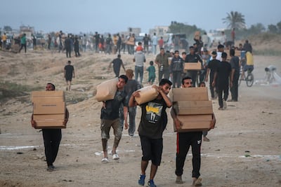 Displaced Palestinians collect food aid in Gaza. Bloomberg