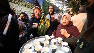 People are served free pastries, as Palestinian Muslim worshippers gather for an early morning prayer around the Ibrahimi Mosque or the Tomb of the Patriarch in Hebron, West Bank. EPA