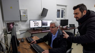Post-doctoral researcher Alexios Liakos talks to senior researcher Manolis Xylouris as they track the comet from the Kryoneri Observatory