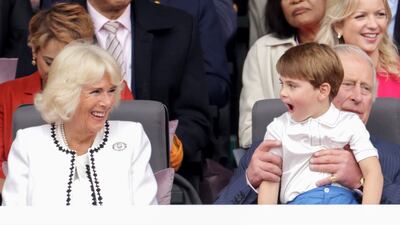 The Duchess of Cornwall laughs with Prince Louis, who is on Prince Charles's lap, during the pageant. PA