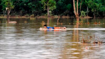 A man floats on flood water at a village in Sanamxai, Attapeu province. AFP