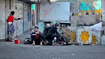 Protesters take cover during clashes with security forces in Baghdad, Iraq. AP Photo