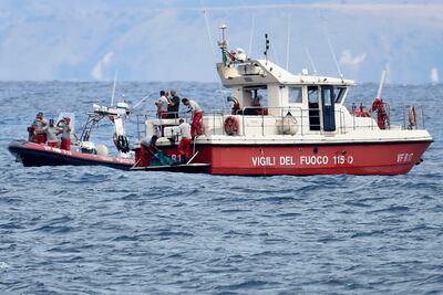 Italian scuba divers prepare take the body of one of the victims ashore on August 21. AP