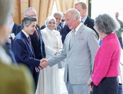 King Charles smiles and shakes hands as he arrives at Cambridge Central Mosque. Reuters