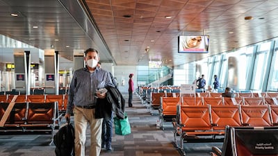 A mask-clad traveller at Doha's Hamad International Airport prepares to board the first Qatar Airways flight bound for Cairo. AFP