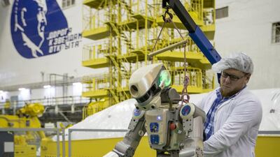 A Roscosmos employee works on the Fedor robot before it is loaded into a Soyuz capsule. AP