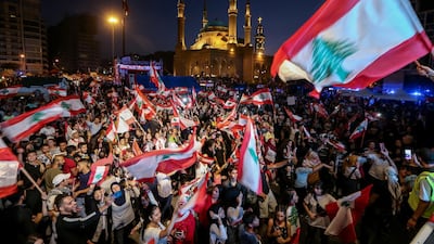 Protesters carry placards, wave Lebanese flags, and shout anti-government slogans during a demonstration in Martyrs' Square in Beirut. EPA