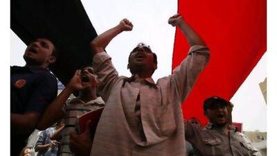 Anti-government protesters shout slogans as they march under a large Yemeni flag during a demonstration to demand the departure of President Ali Abdullah Saleh in the southern city of Taiz yesterday. Khaled Abdullah / Teuters