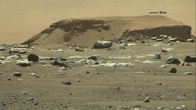 A tall outcropping of rock, with layered deposits of sediments in the distance, marking a remnant of an ancient, long-vanished river delta in Jezero Crater. Reuters