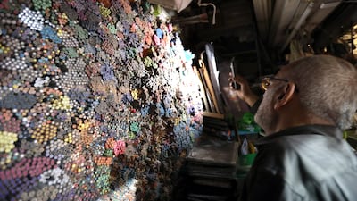 Ali Al Mandalawi uses the torchlight of his mobile phone to search for a pencil in his shop at the Al Saray market in central Baghdad. All photos: EPA