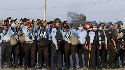 Police officers fire tear gas shells to disperse PTI supporters, in Islamabad. AP