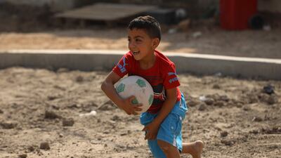 A child plays with a ball in the playground of a shelter for families of Lebanese refugees, in the Iraqi city of Hilla, on October 18. AFP