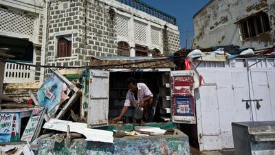 A shopkeeper cleans his roadside stall following Cyclone Phailin in Gopalpur, India. Manan Vatsyayana / AFP Photo