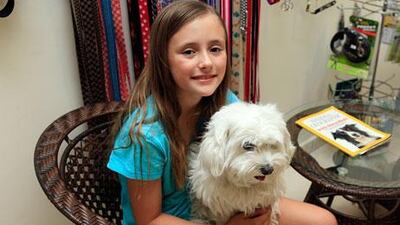 Freya Kelly holding her prize-winning dog Honey Bunch while he's being groomed at the Energetic Panacea clinic, ahead of the Dubai Pet Show in Dubai. Satish Kumar / The National