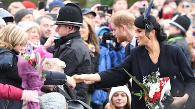 Meghan, Duchess of Sussex (R) and Britain's Prince Harry, Duke of Sussex greet the crowds after the Royal Family's traditional Christmas Day service at St Mary Magdalene Church in Sandringham, Norfolk, eastern England. AFP