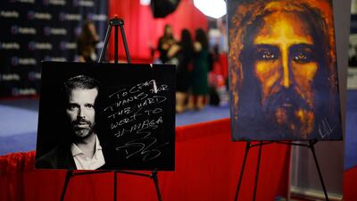 An autographed photograph of Donald Trump Jr is displayed next to a portrait of Jesus Christ at the Conservative Political Action Conference, in Fort Washington, Maryland. AFP