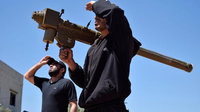 Rebel-fighters monitor the sky holding a FN-6 man-portable air-defence system (MANPADS) in the Syrian village of Teir Maalah, near Homs. AFP
