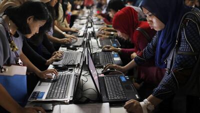 Indonesian youths fill up job application forms on laptops provided by the organisers at Kompas Karier Fair in Jakarta. Employment levels rose for the second consecutive month in July, Although the pace of job creation was modest, it was the largest rise in workforce numbers since July 2013. Beawiharta / Reuters
