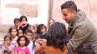 Ali Alsonidar showing children some photos he took of them. Ali Alsonidar