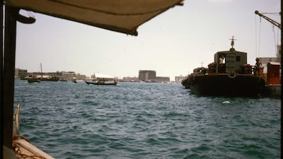 Travelling across Dubai Creek the traditional way. A Gray Mackenzie and Co barge, right, carried goods from ships offshore to customs on the quayside
