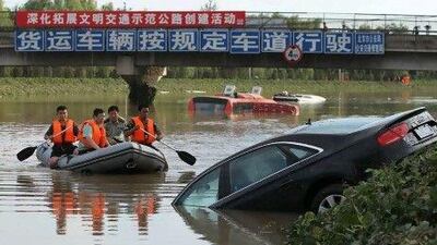 A rescue boat approaches a partially submerged car after the heaviest rainfall in six decades hit Beijing’s Fangshan district.