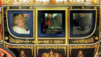 Queen Elizabeth smiles as she looks out of the window of her horse drawn carriage as she arrives at Buckingham Palace after delivering her annual speech in 2003. Getty Images