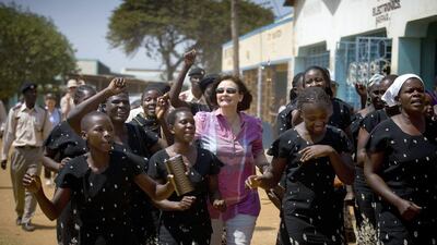 Cherie Blair, chairperson of the Cherie Blair Foundation, dances with women from the Nango Women's Association near Bondo, Kenya. Kate Holt / Care International