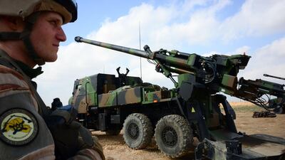 A French soldier engaged in Operation Chammal stands guard in front of a wheeled 155mm gun-howitzer Caesar system on February 9, 2019, near Al Qaim in Iraq. AFP