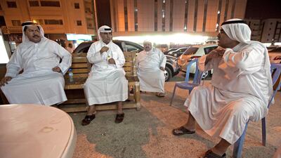 Ajman, August 8, 2011 - Almost every night these men gather an indoor majlis, between a gents saloon and a cafeteria, where they can escape the heat inside or drink tea, plays cards and talk outside in the Al Nakeel neighborhood near the Gold Souk in Ajma???
